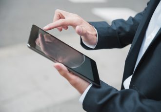 close-up-businessman-s-hand-using-digital-tablet